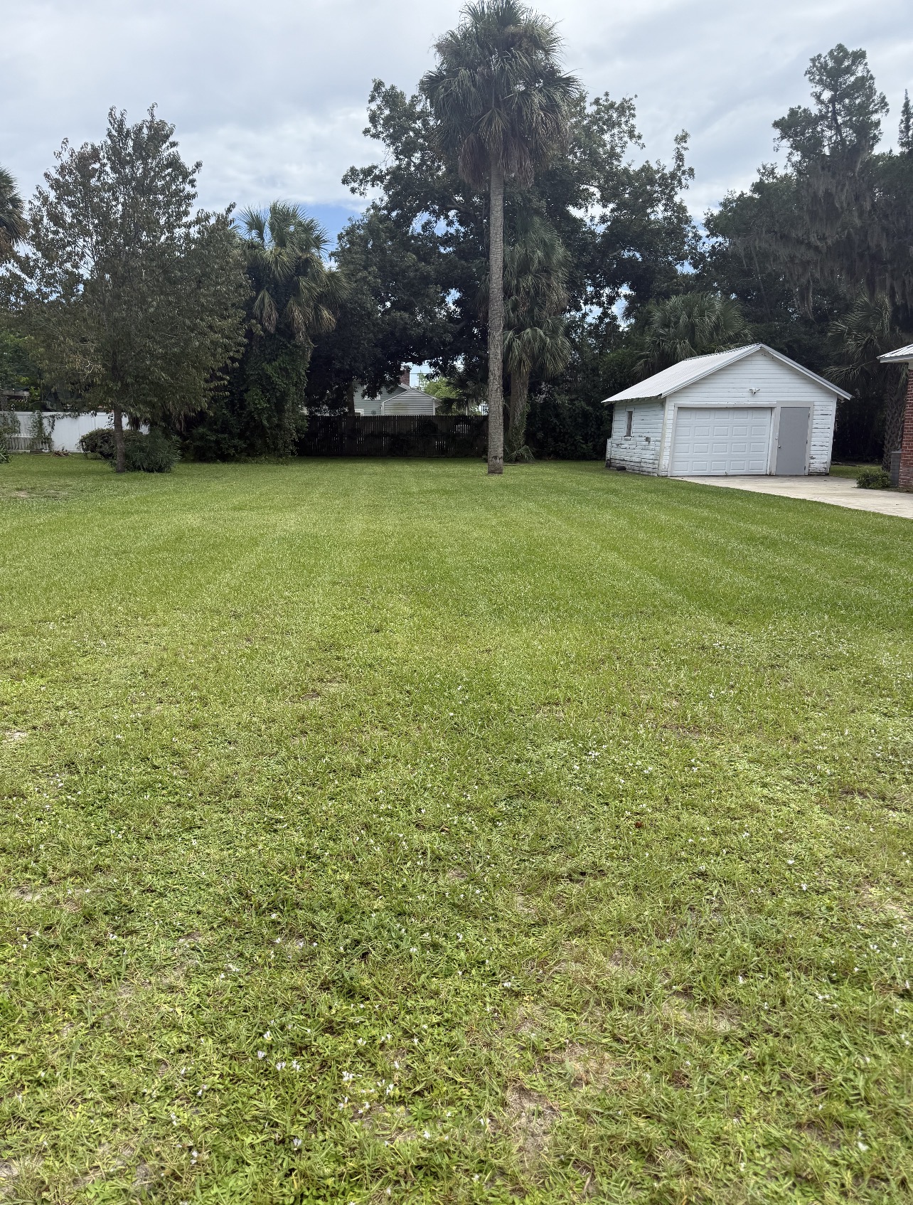 Wide property cut evenly around the garage and trees